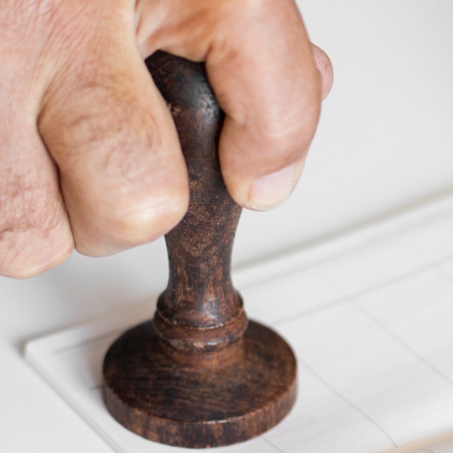 An official stamp being pressed onto a document